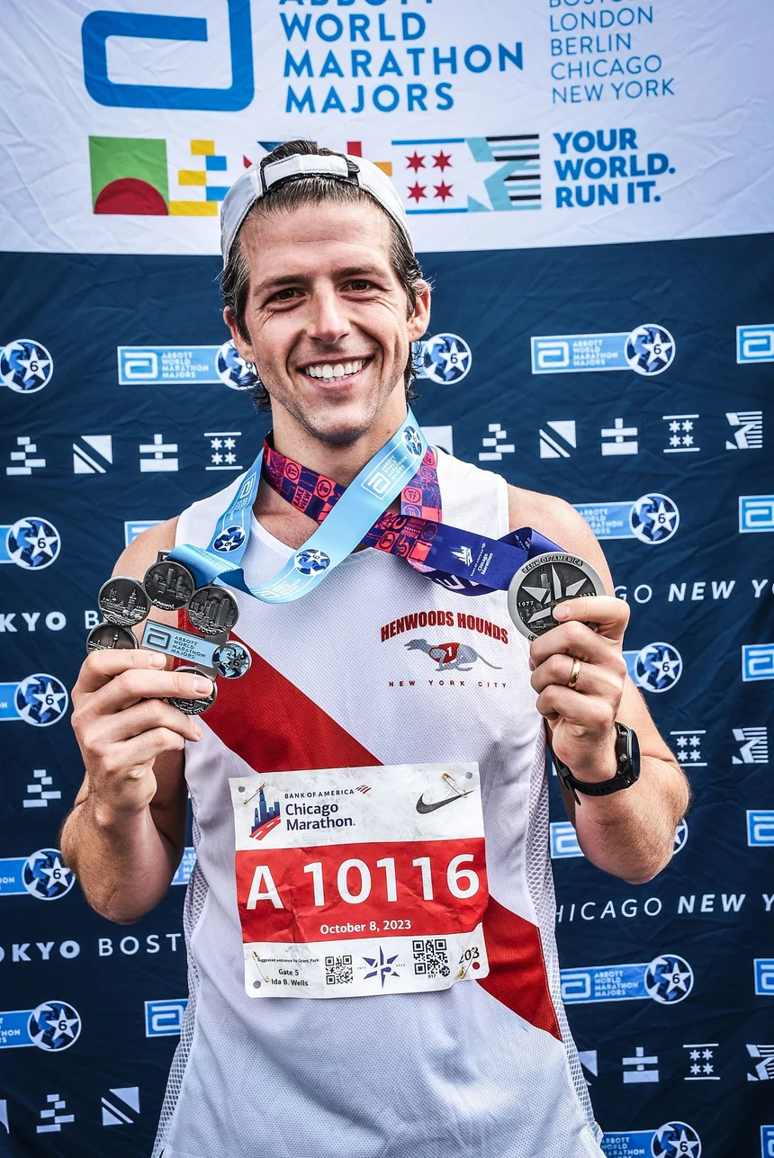 Jason holding his marathon finisher medals in Chicago